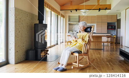 室内で読書するシニア女性 室内で読書するシニア女性 128414116