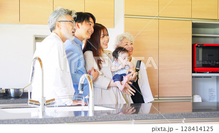笑顔で赤ちゃんを囲む三世代家族 笑顔で赤ちゃんを囲む三世代家族 128414125