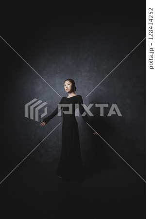 黒背景でポーズをとる女性 128414252