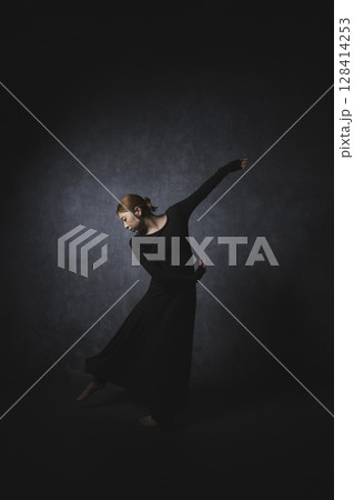 黒背景でポーズをとる女性 128414253