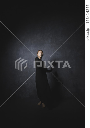 黒背景でポーズをとる女性 128414255