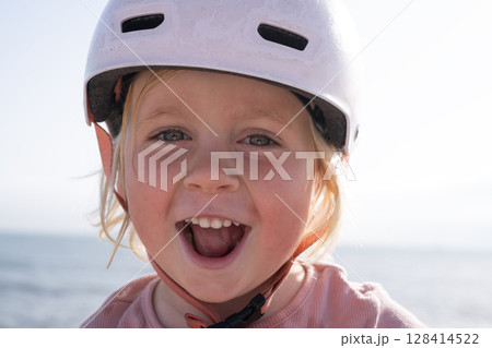 Girl in a Bike Helmet Happily Looking at the Camera 128414522