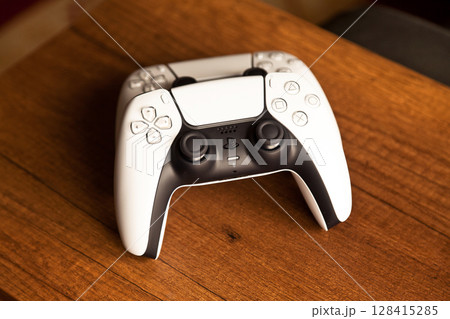 Sony PS5 Wireless Controller, on an oak wooden table, PlayStation is a video gaming brand that consists of five home video game consoles. Istanbul Turkey May 01 2025 Sony PS5 Wireless Controller, on an oak wooden table, PlayStation is a video gaming brand that consists of five home video game consoles. Istanbul Turkey May 01 2025 128415285