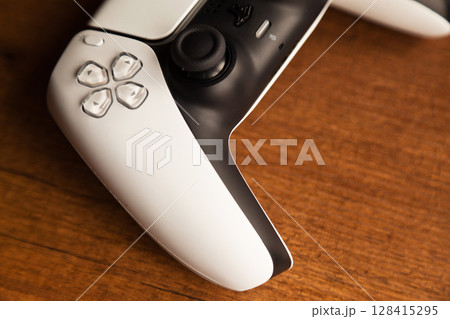 Sony PS5 Wireless Controller, on an oak wooden table, PlayStation is a video gaming brand that consists of five home video game consoles. Istanbul Turkey May 01 2025 Sony PS5 Wireless Controller, on an oak wooden table, PlayStation is a video gaming brand that consists of five home video game consoles. Istanbul Turkey May 01 2025 128415295