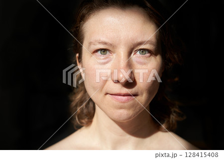 Young caucasian female with short hair and green eyes in soft light portrait Young caucasian female with short hair and green eyes in soft light portrait 128415408