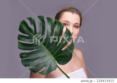 Caucasian female adult with monstera leaf, natural beauty and skincare concept Caucasian female adult with monstera leaf, natural beauty and skincare concept 128415415