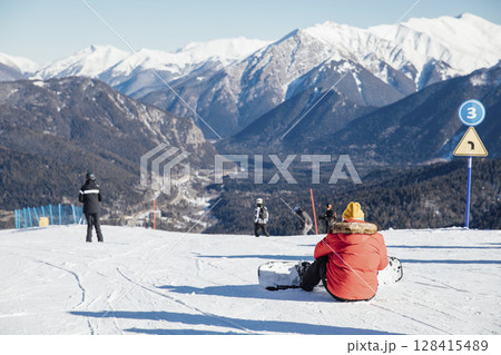 Skiers, snowboarders skiing in a mountain ski 128415489