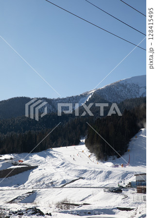 Snowboarders and skiers ski in the ski resort on the slopes 128415495