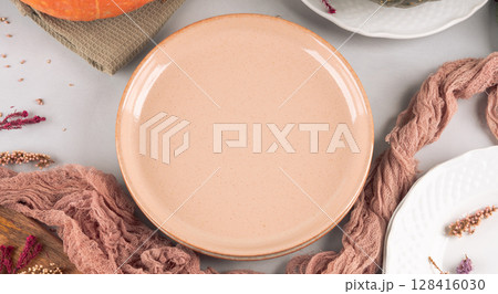 Fall thanksgiving table setting pumpkin decor flatlay with pink dish 128416030