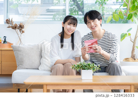 リビングでくつろぐ若いカップル 128416333