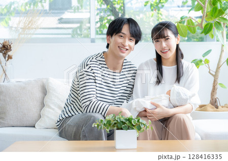 リビングで赤ちゃんを抱く若い家族 128416335
