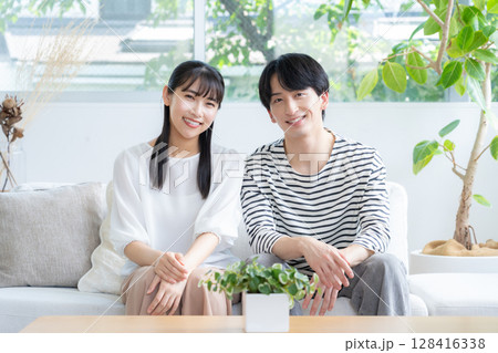 リビングでくつろぐ若いカップル リビングでくつろぐ若いカップル 128416338