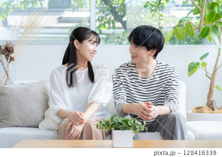 リビングでくつろぐ若いカップル リビングでくつろぐ若いカップル 128416339