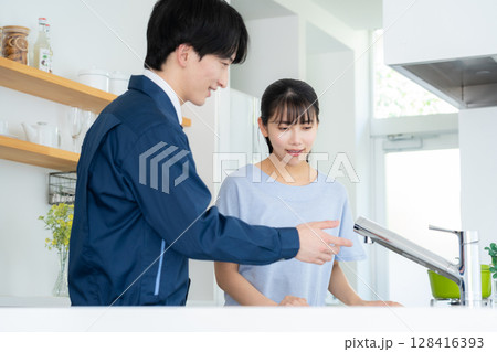 キッチンで女性に説明をする不動産業者 128416393