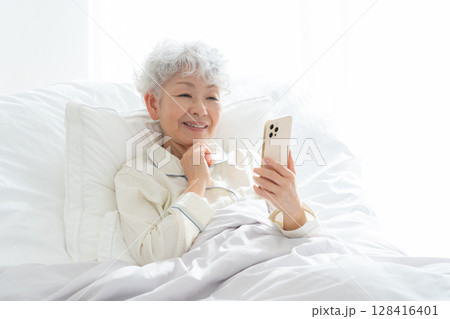 ベッドで寝ているシニア女性 128416401