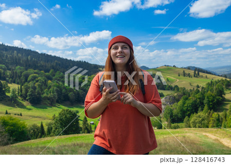 Young Woman Hiking with Map and Smartphone in Scenic Countryside 128416743