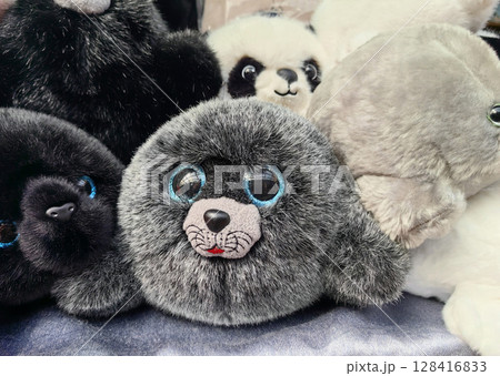 stuffed animals in various poses showcasing adorable features in cozy display setting. closeup. 128416833