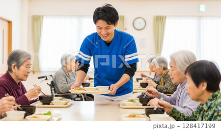 高齢者施設で食事を提供する女性介護士　配膳、ランチタイム、給食、食事、楽しみ 128417199