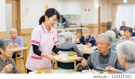 高齢者施設で食事を提供する女性介護士　配膳、ランチタイム、給食、食事、楽しみ 128417202
