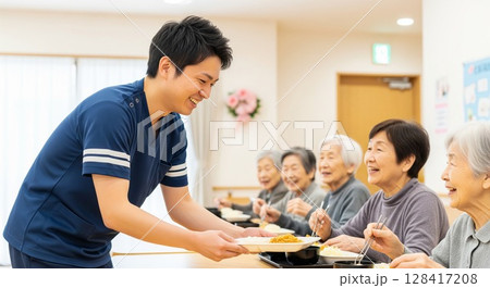 高齢者施設で食事を提供する女性介護士　配膳、ランチタイム、給食、食事、楽しみ 128417208