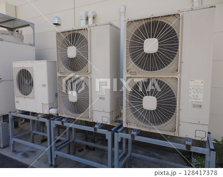 屋外に設置されたエアコン室外機 128417378
