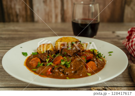 Delicious beef stew with vegetables and wine pairing Delicious beef stew with vegetables and wine pairing 128417617