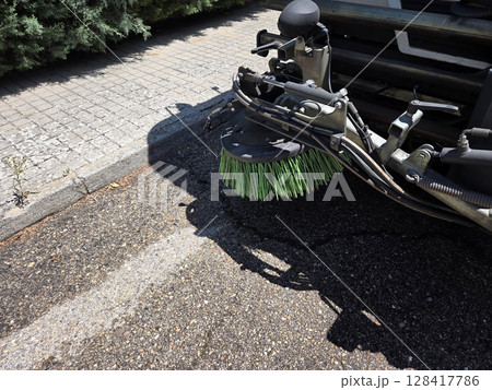 Urban cleanliness concept with street sweeper close-up on pavement. A street sweeper or street cleaner Urban cleanliness concept with street sweeper close-up on pavement. A street sweeper or street cleaner 128417786