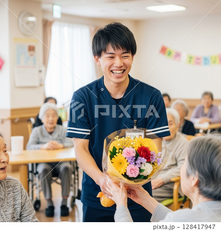 高齢者施設で生き生きと働く女性介護士　お誕生日の花束を渡す　ヘルパー、お仕事、介護、お世話 128417947