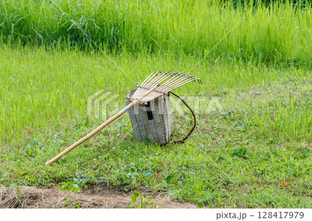刈った草を集める熊手と竹かご 128417979