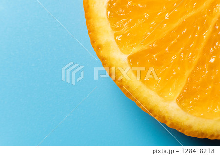 Orange slice, on a blue background. Top view. Flat lay, macro shot. Banner concept for advertising Orange slice, on a blue background. Top view. Flat lay, macro shot. Banner concept for advertising 128418218