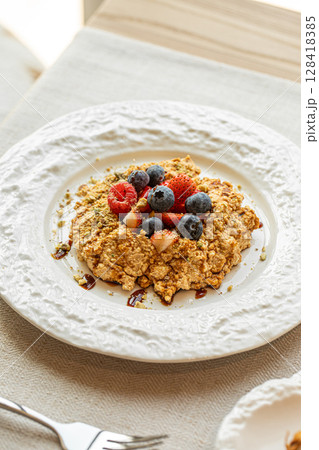 Crumble dessert with berries on white plate Crumble dessert with berries on white plate 128418385