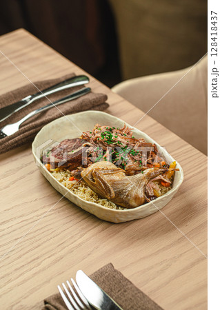 Plov with chicken and beef served in ceramic bowl 128418437