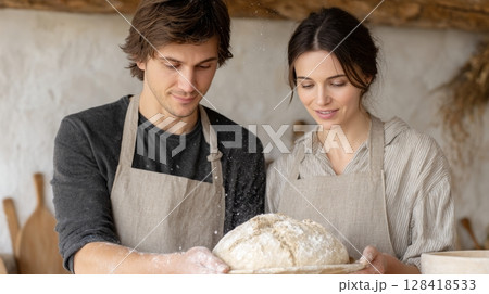 Couple shares a cozy moment as they bake sourdough bread in a warm and inviting kitchen 128418533