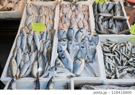 Variety of fresh fish displayed at a local market in the early morning sunlight Variety of fresh fish displayed at a local market in the early morning sunlight 128418800