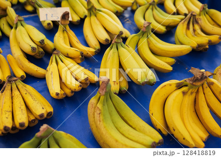 Fresh bananas for sale at local market with vibrant colors and appealing arrangement 128418819