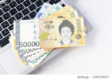 韓国の通貨、ウォンKRWの紙幣とノートパソコン 韓国の通貨、ウォンKRWの紙幣とノートパソコン 128419037