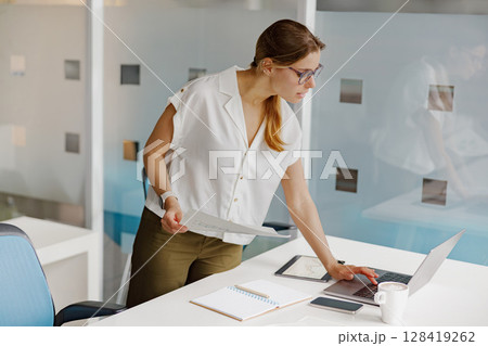Professional Woman Successfully Working in a Modern Office Environment Focusing on Tasks Professional Woman Successfully Working in a Modern Office Environment Focusing on Tasks 128419262