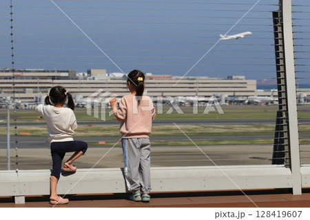 空港の展望デッキから飛行機を眺める子供二人 空港の展望デッキから飛行機を眺める子供二人 128419607