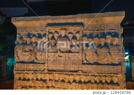 Night view of the detailed stone relief on the Obelisk of Theodosius in Istanbul, Turkey, showing an emperor and attendants in a ceremonial scene. Night view of the detailed stone relief on the Obelisk of Theodosius in Istanbul, Turkey, showing an emperor and attendants in a ceremonial scene. 128419788