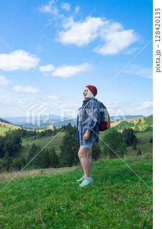 Senior woman enjoying scenic mountain landscape during hike Senior woman enjoying scenic mountain landscape during hike 128420135