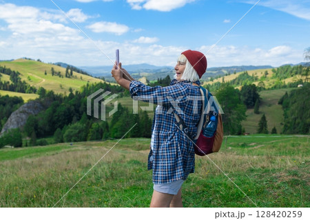 Happy Female Hiker Taking Selfie in Scenic Mountain Landscape Happy Female Hiker Taking Selfie in Scenic Mountain Landscape 128420259