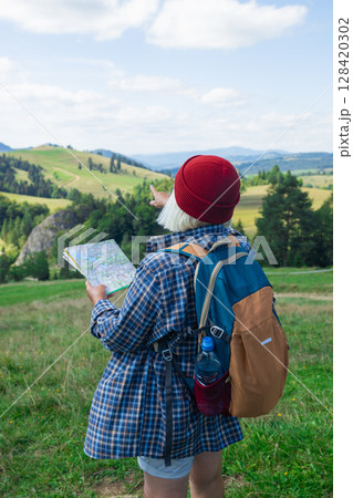Female Hiker Navigating with a Map in the Mountains Female Hiker Navigating with a Map in the Mountains 128420302