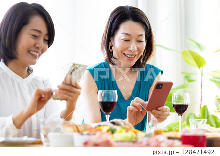 パーティ料理の写真を撮る女性 128421492