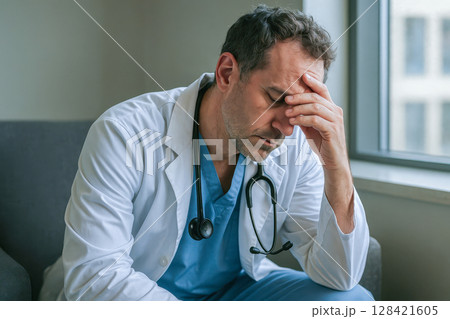 Sad doctor feeling guilt after medical mistake, mental health, anxiety, difficult professional responsibility, ethical problem, pressure in healthcare system 128421605