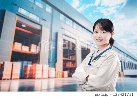物流拠点で働く作業服姿の若い女性 128421711