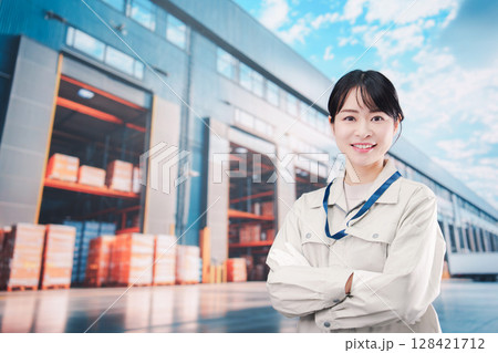 物流拠点で働く作業服姿の若い女性 物流拠点で働く作業服姿の若い女性 128421712