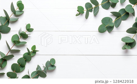 Green leaves frame a wooden background with a fresh floral border illustrating natural spring foliage 128422018