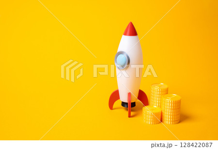Rocket and a stack of coins. Startups and advertising. Space race. Business launches, venture capital, or bold marketing investments. Space exploration, innovation, risk taking in emerging industries. 128422087