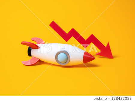 Rocket and red arrow down. Failed startup, failed advertising campaign. Problems in the space industry. Declining investor confidence, or instability in ambitious tech sectors like aerospace. 128422088
