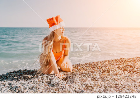 Woman in Santa Hat on a Pebble Beach Woman in Santa Hat on a Pebble Beach 128422248